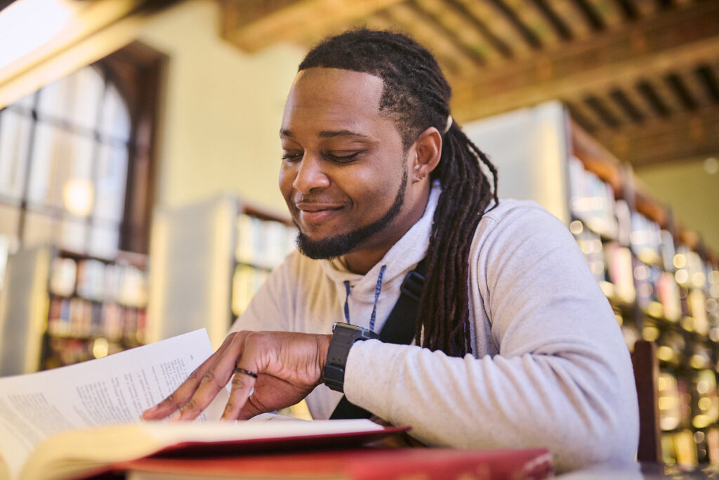 A person reading a book in a library.