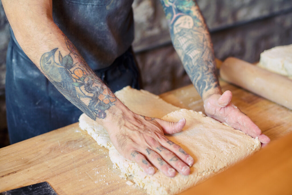 Closeup of a person shaping biscuit dough.