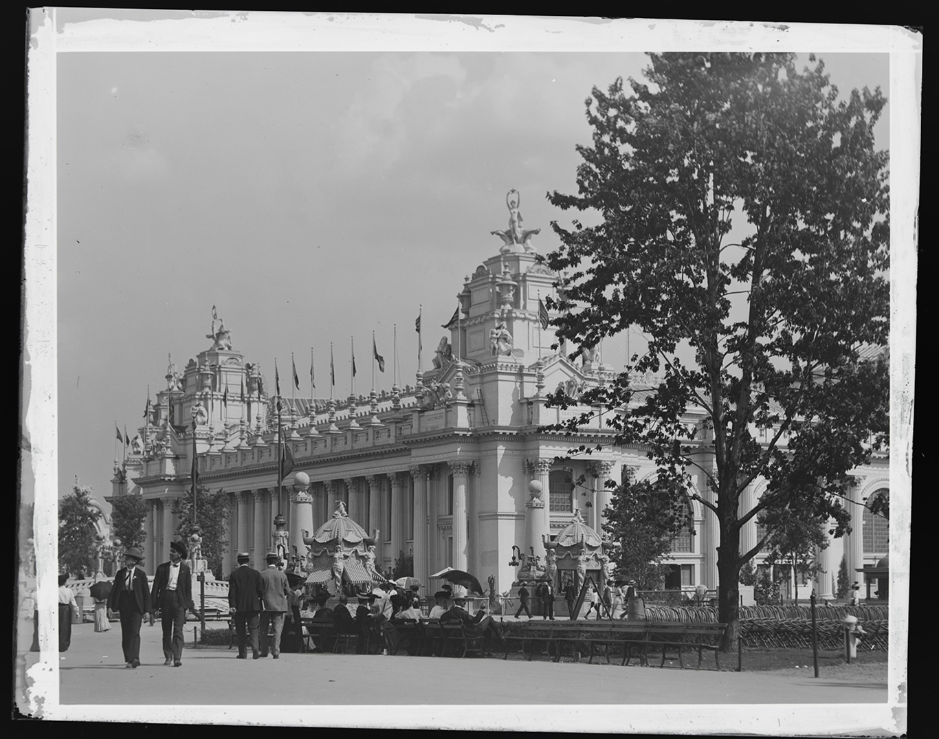 Visitors walk past a large palace at the 1904 World's Fair.