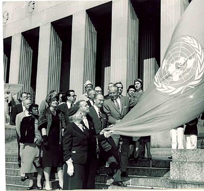 A group of people, including James S. McDonnell, gathered on the steps of Soldiers Memorial to unveil a UN flag.