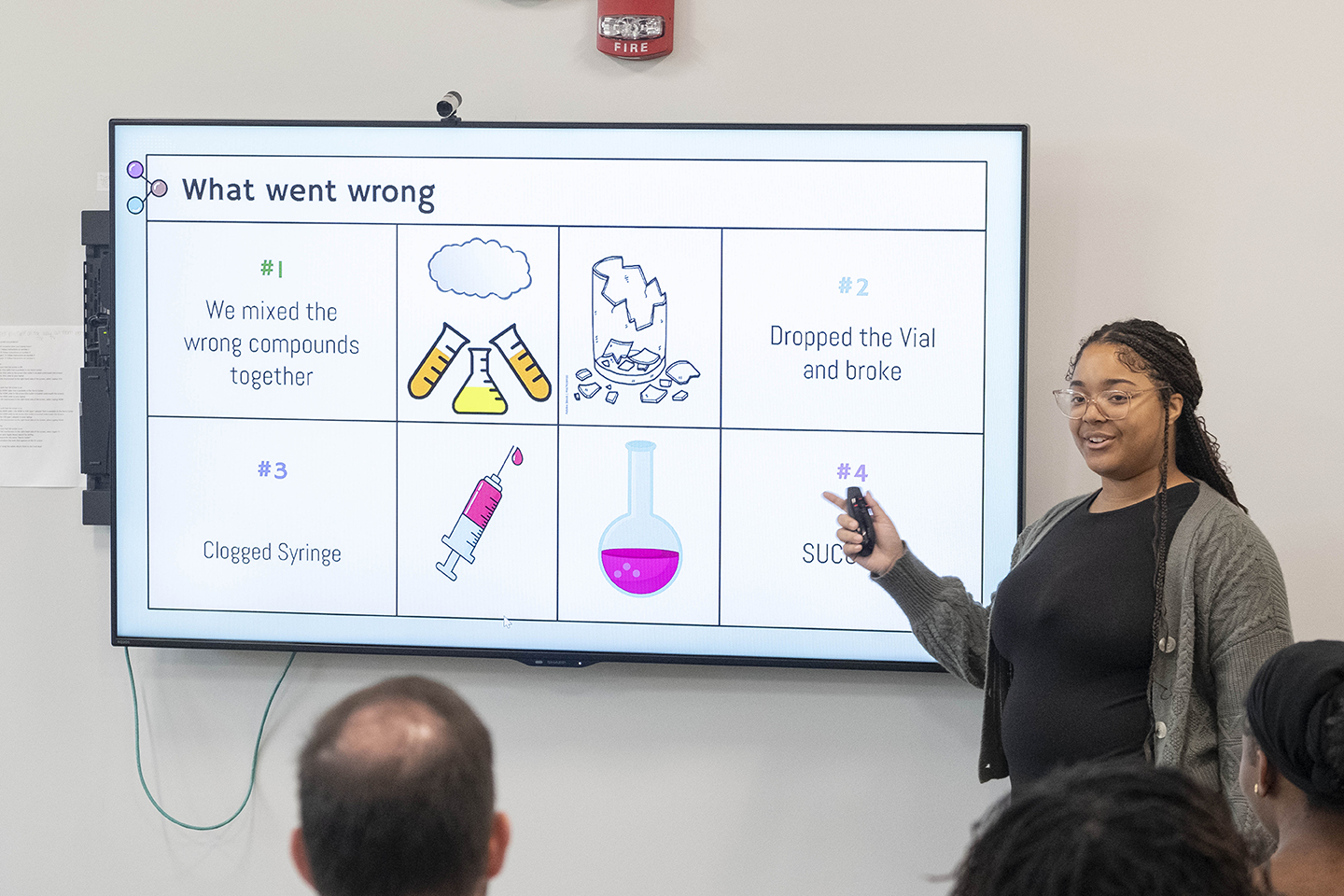 Vajah Bassett delivering a presentation as part of the CLIMB program. The presentation slide is titled What went wrong and features three failed attempts before finding success on the fourth try.