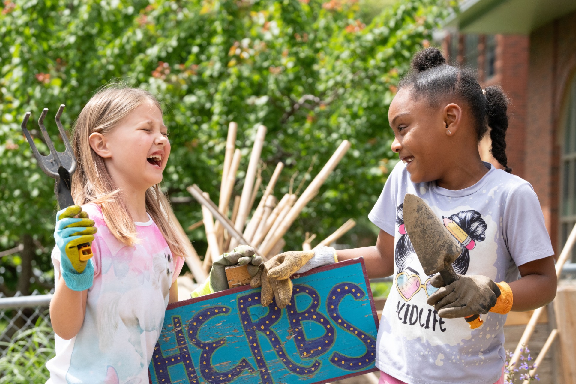 Two young students gardening together outside.