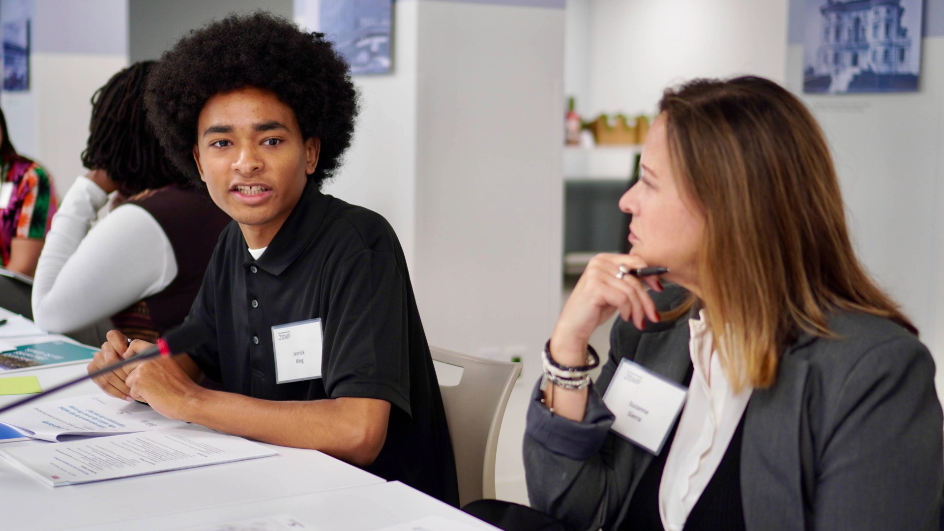 Two individuals talking at an IPP meeting.